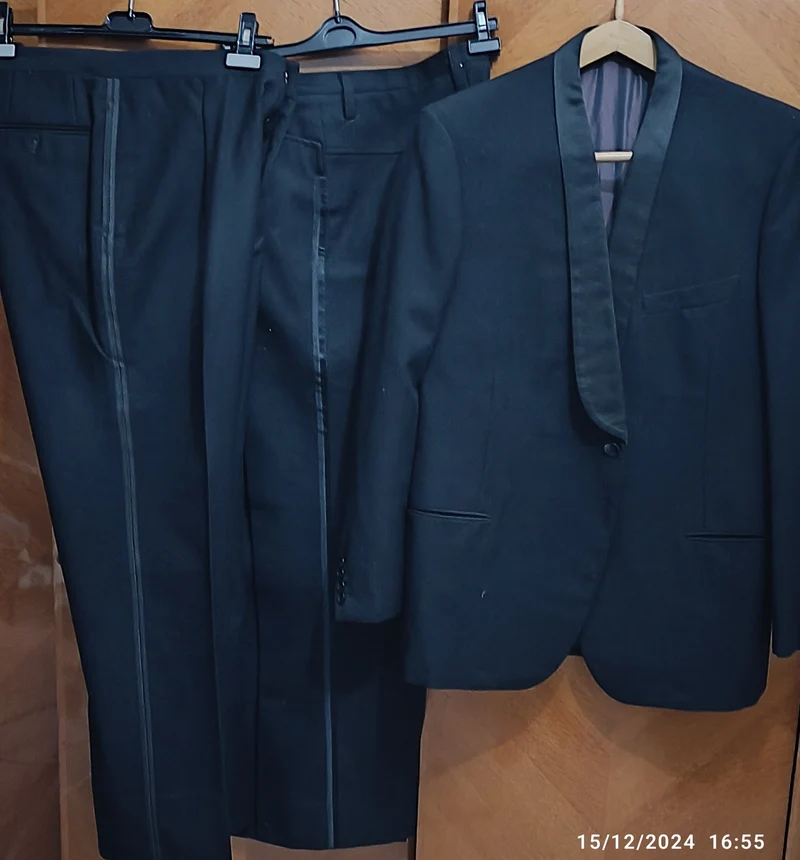 Abbigliamento vintage. Smoking nero, pura lana, sartoria Monti, fine anni sessanta, con due paia di pantaloni di fattura diversa. Indossato da persona di 182 cm. 2kg.