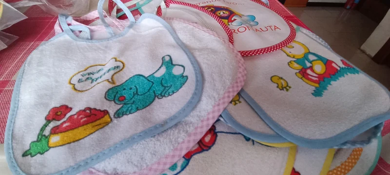 Cinque bavaglini assortiti, di puro cotone e cotone con gomma per pappa. 200g.