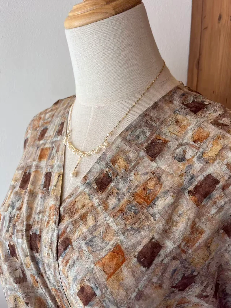 Abito midi stampato nei toni del beige e del marrone con scollo incrociato