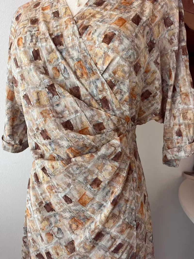 Abito midi stampato nei toni del beige e del marrone con scollo incrociato